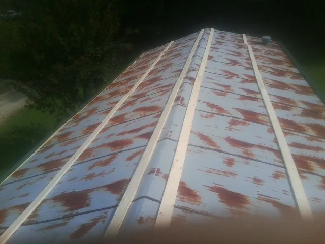 Rusted metal roof panels with new wood purlins before replacement — Storm Damage Roof Repair in Sparta by Roofing Brothers